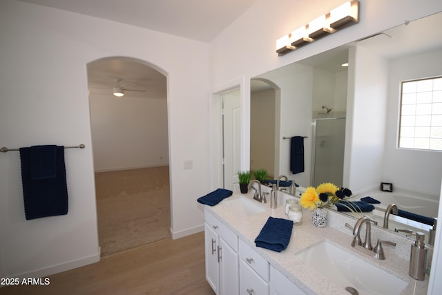 28377 N Desert Native St, San Tan Valley, AZ 85143 - full bathroom featuring a stall shower, double vanity, a ceiling fan, a bath, and wood finished floors