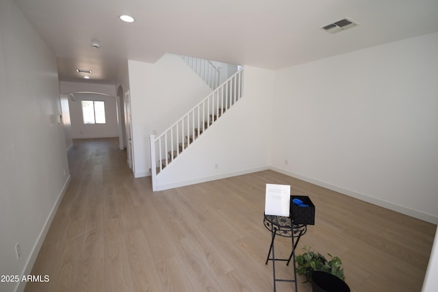 28377 N Desert Native St, San Tan Valley, AZ 85143 - unfurnished living room with light wood-style floors, arched walkways, stairway, and recessed lighting