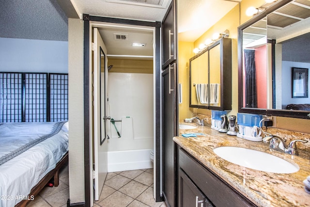 ensuite bathroom with tile patterned flooring, a sink, visible vents, and connected bathroom