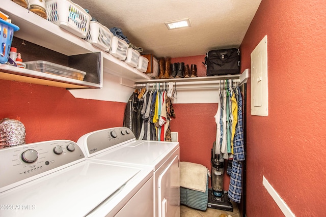 clothes washing area featuring laundry area, electric panel, a textured wall, and separate washer and dryer