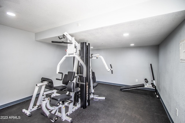 workout area with recessed lighting, a textured ceiling, and baseboards