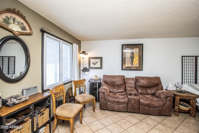 living room with a textured ceiling and light tile patterned floors