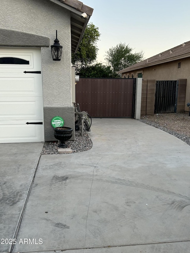 view of patio featuring fence, driveway, and a gate