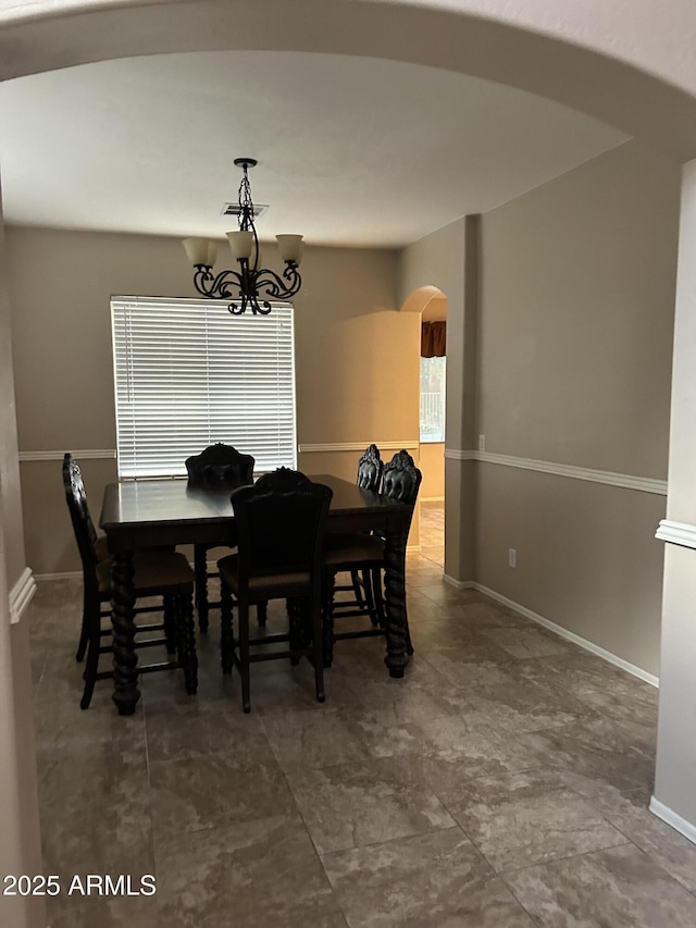 dining room featuring visible vents, a notable chandelier, baseboards, and arched walkways