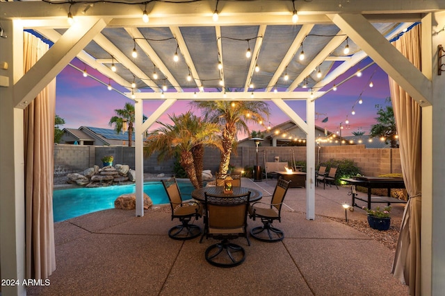 patio terrace at dusk with a pergola, a fenced in pool, and an outdoor fire pit