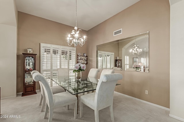 dining space with carpet floors, high vaulted ceiling, and a chandelier