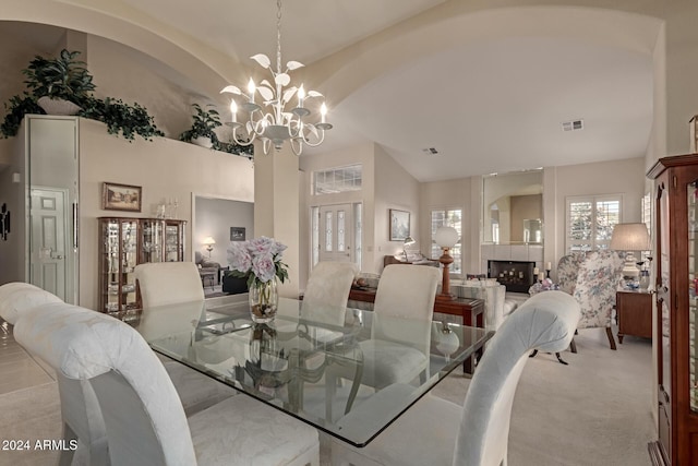 dining space with a chandelier, light carpet, and lofted ceiling