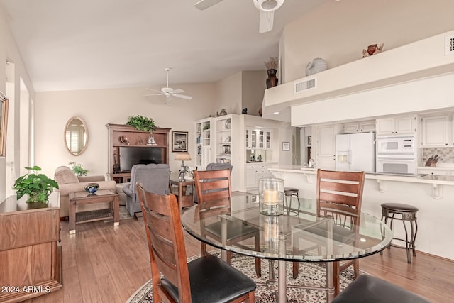 dining area featuring ceiling fan, light hardwood / wood-style flooring, and high vaulted ceiling