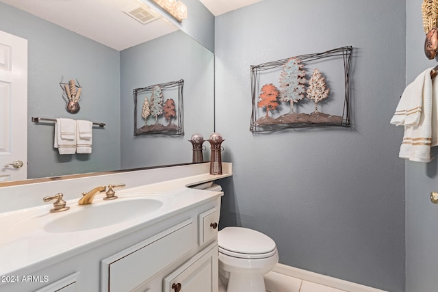 bathroom with tile patterned flooring, vanity, and toilet