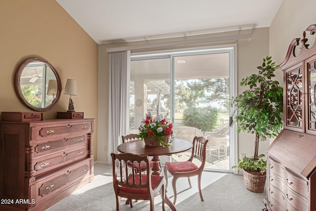 carpeted dining space featuring a healthy amount of sunlight and vaulted ceiling