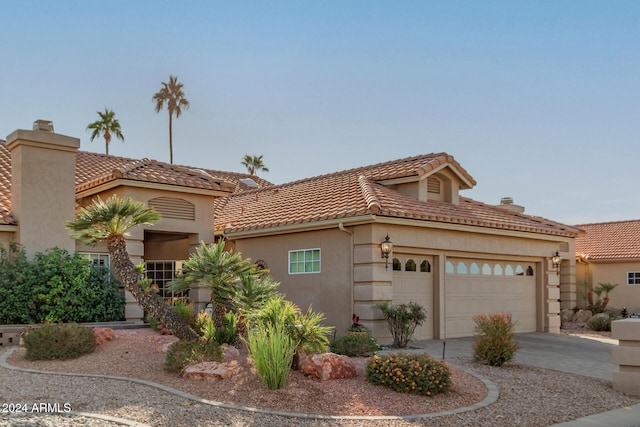 mediterranean / spanish-style home with a garage