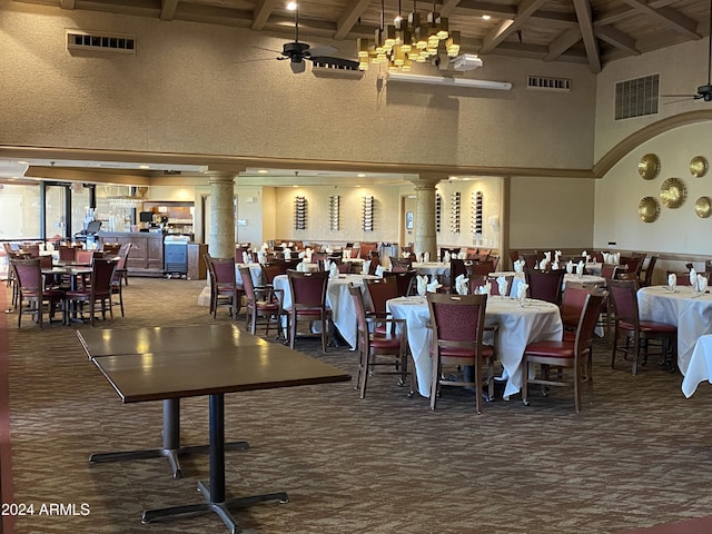 carpeted dining space with beamed ceiling, ceiling fan with notable chandelier, and high vaulted ceiling