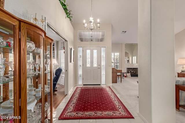 carpeted foyer with a high ceiling and a chandelier