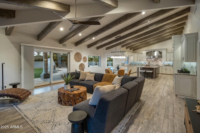 living room featuring ceiling fan, vaulted ceiling with beams, wooden ceiling, and light hardwood / wood-style floors