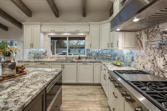 kitchen featuring white cabinetry, sink, and exhaust hood