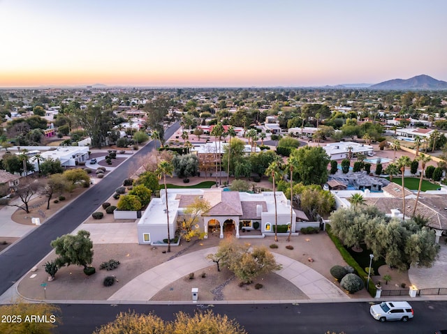 aerial view at dusk featuring a mountain view