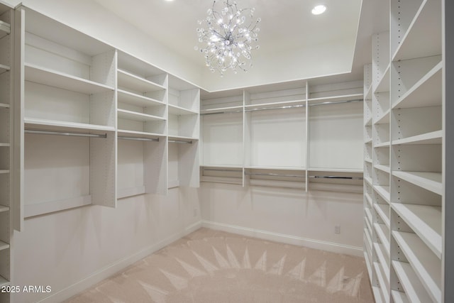 walk in closet with carpet flooring and a chandelier