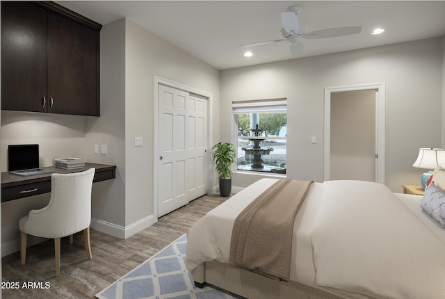 bedroom with light hardwood / wood-style flooring, a closet, and ceiling fan