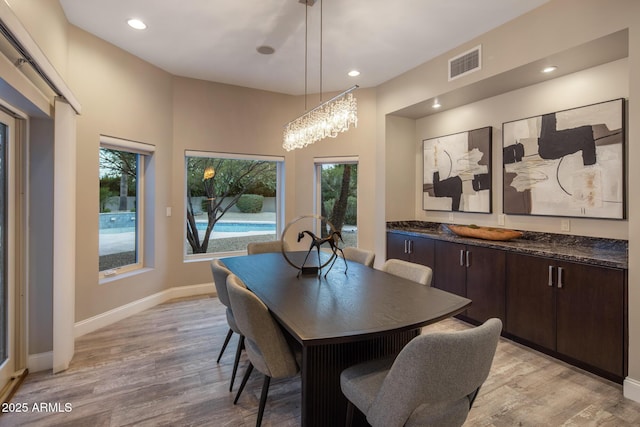 dining room with an inviting chandelier and light hardwood / wood-style flooring