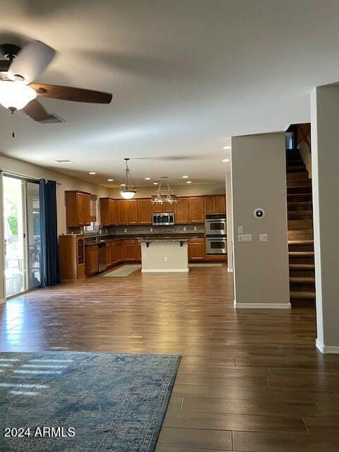 unfurnished living room with ceiling fan and dark wood-type flooring