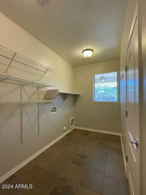 laundry area featuring hookup for an electric dryer, hookup for a washing machine, dark tile patterned flooring, and gas dryer hookup