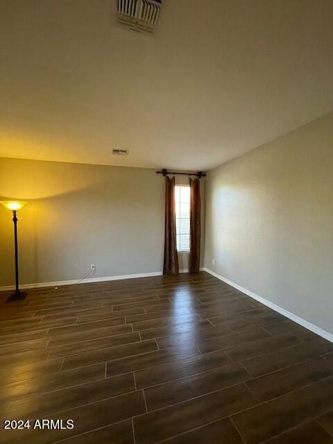 empty room with dark hardwood / wood-style flooring