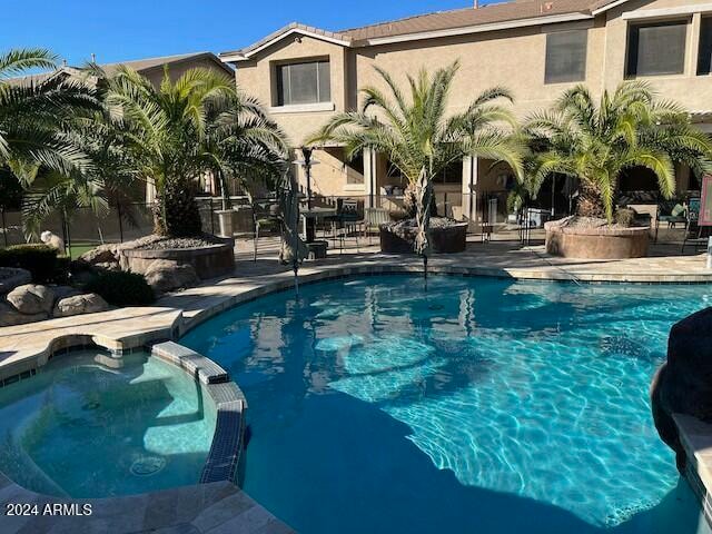 view of pool featuring an in ground hot tub and a patio