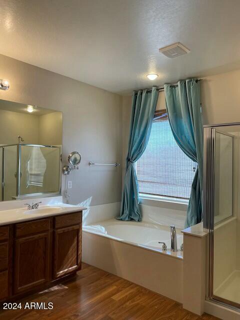 bathroom featuring vanity, plus walk in shower, and hardwood / wood-style flooring