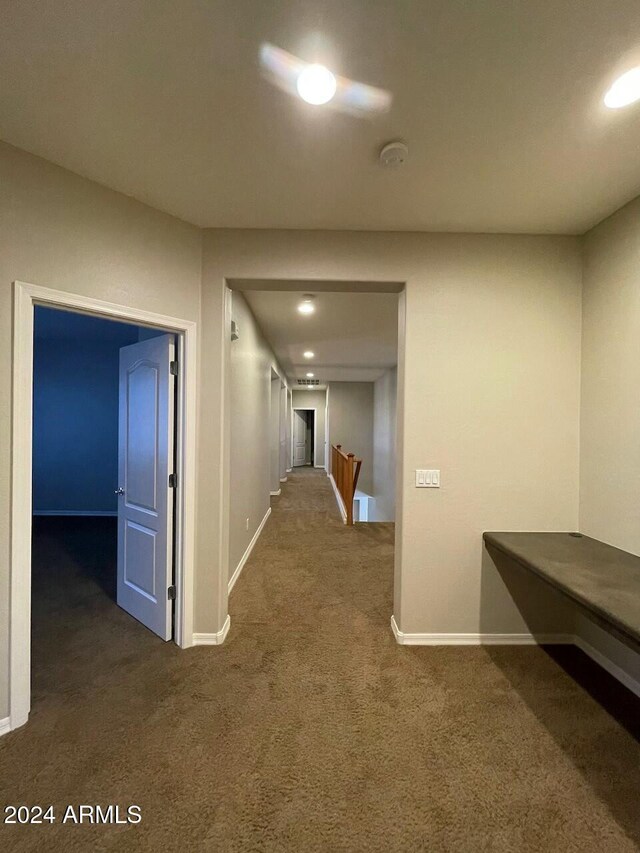 hallway featuring dark colored carpet