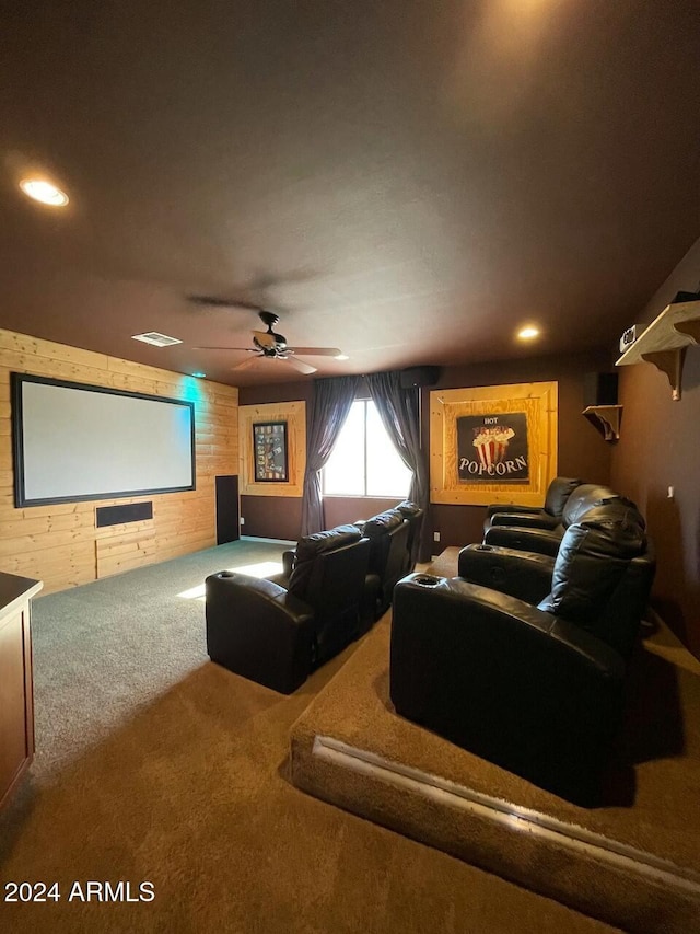 cinema room featuring carpet floors, ceiling fan, and wooden walls