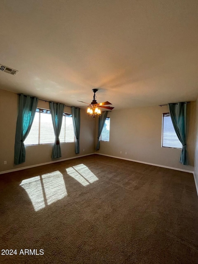 unfurnished room featuring ceiling fan and dark carpet