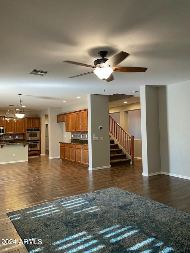 unfurnished living room featuring dark hardwood / wood-style flooring and ceiling fan