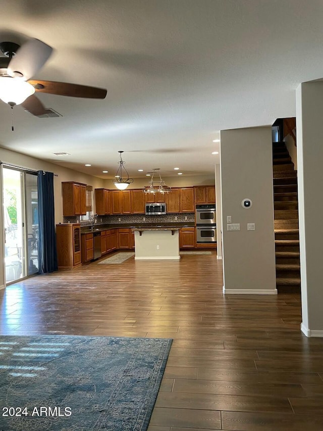 unfurnished living room featuring dark hardwood / wood-style floors and ceiling fan