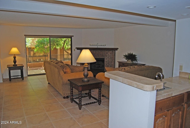 tiled living room with a brick fireplace and sink