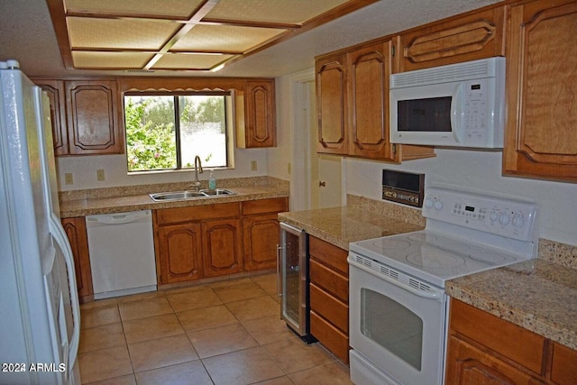 kitchen featuring white appliances, light tile patterned floors, a textured ceiling, beverage cooler, and sink