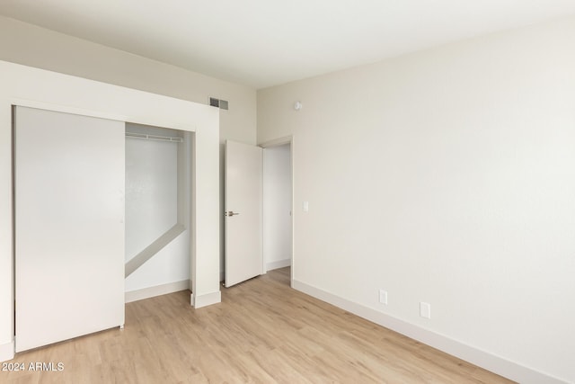 unfurnished bedroom featuring a closet and light hardwood / wood-style flooring