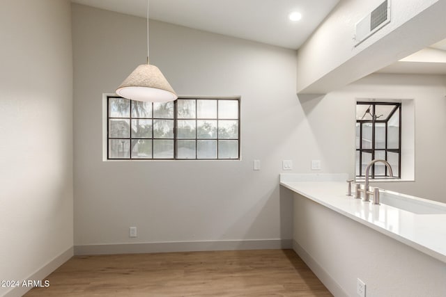 unfurnished dining area featuring light wood-type flooring and lofted ceiling