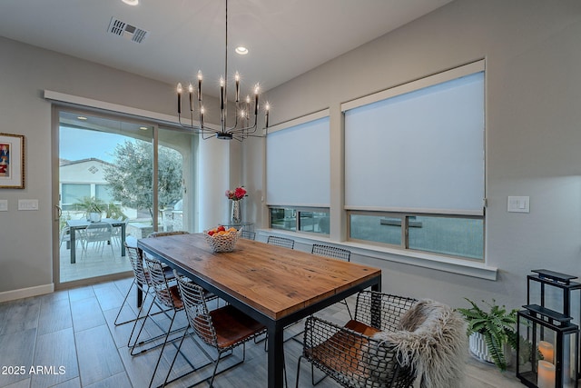 dining space featuring light wood-type flooring and a chandelier