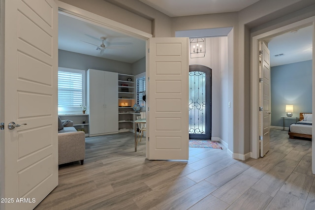 foyer entrance with light hardwood / wood-style floors and ceiling fan