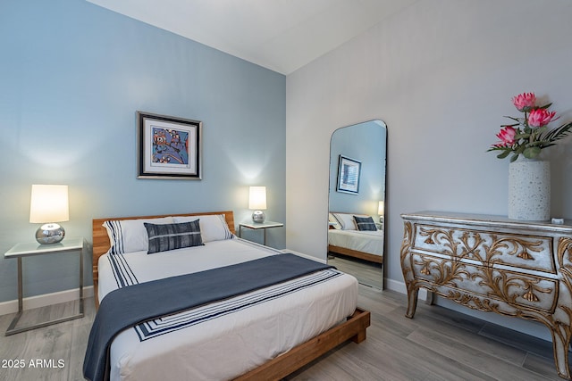 bedroom featuring light wood-type flooring and vaulted ceiling