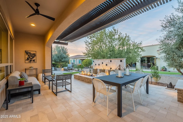 patio terrace at dusk featuring an outdoor living space, ceiling fan, and a pergola