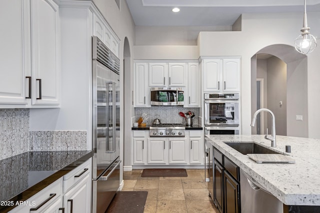 kitchen featuring stainless steel appliances, sink, hanging light fixtures, and white cabinets