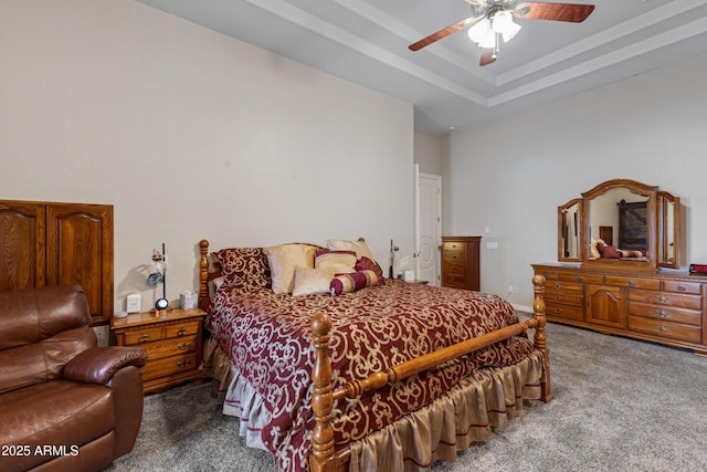 carpeted bedroom featuring ceiling fan and a raised ceiling