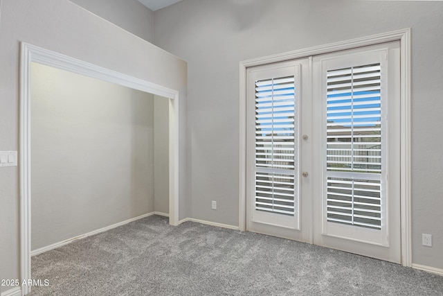 spare room featuring light colored carpet and french doors