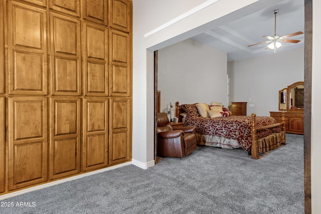 carpeted bedroom with ceiling fan and a tray ceiling