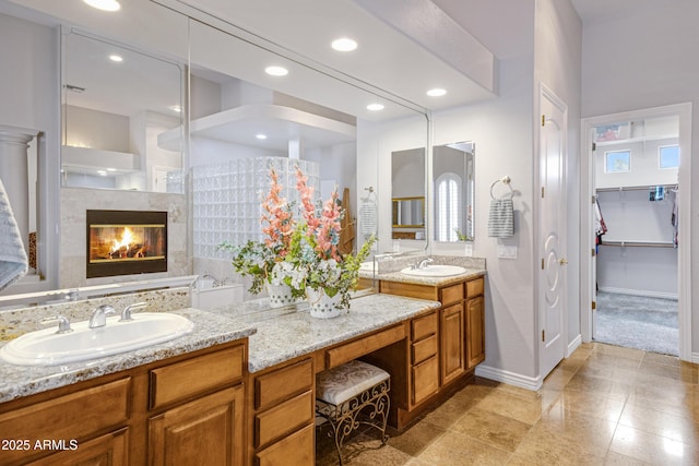 bathroom with vanity, a tub to relax in, and a fireplace