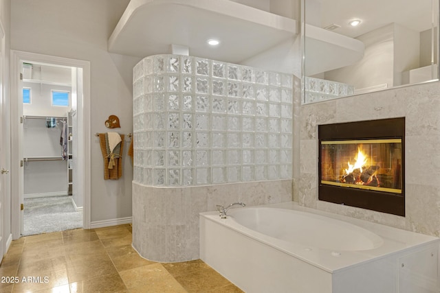 bathroom featuring a tile fireplace and independent shower and bath