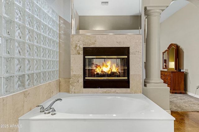 bathroom featuring a bath and ornate columns