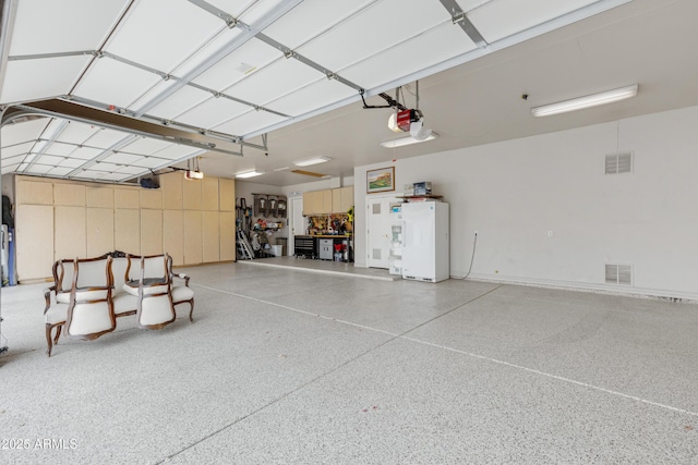 garage featuring a garage door opener and white fridge