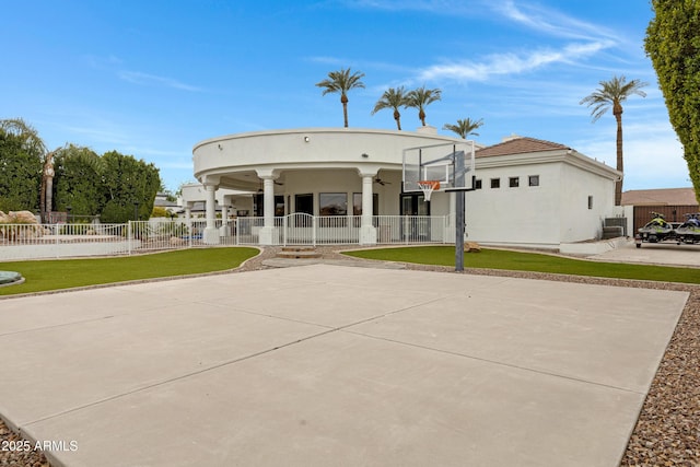 view of front of house with central AC, ceiling fan, basketball court, and a front lawn